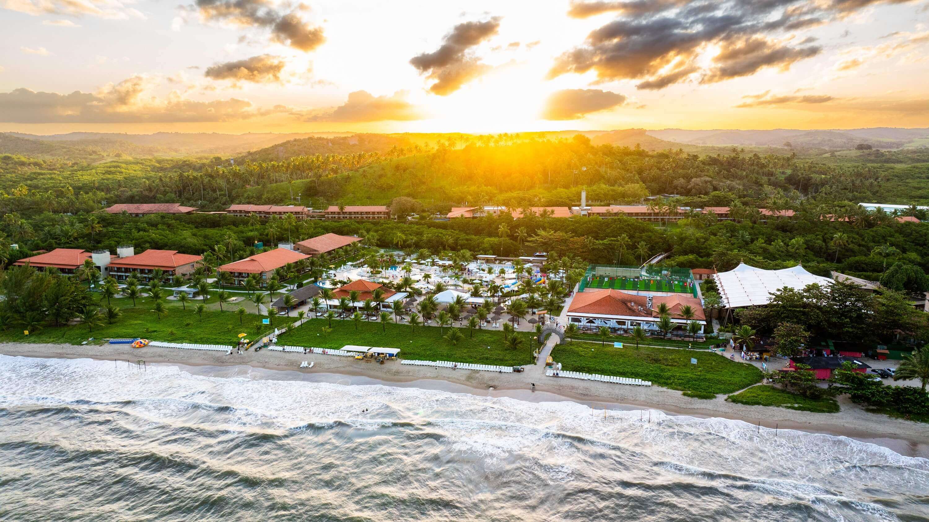 Vista aérea do resort All Inclusive Salinas Maragogi à beira-mar durante por do sol.